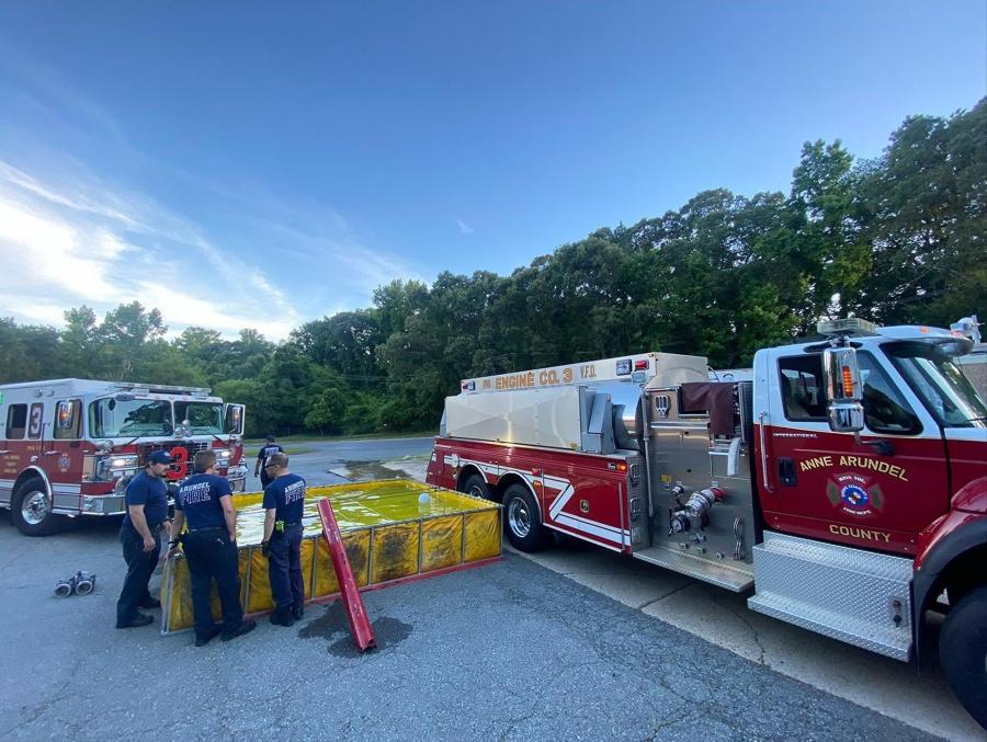 Members working a tanker water-supply drill behind the station