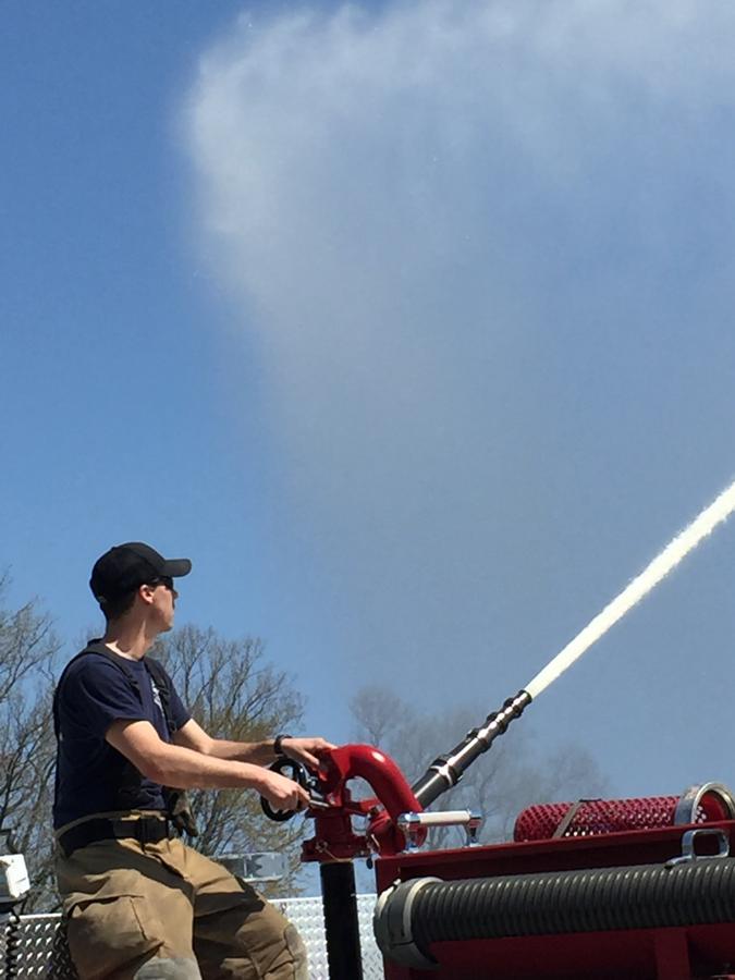 A young member flowing the deck gun during pump training