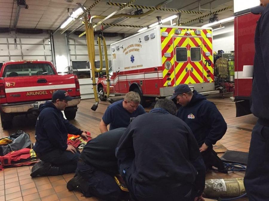 Crew members training around a stretcher beside the medic unit